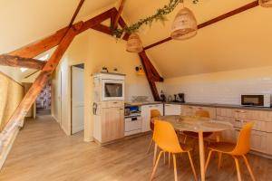 a kitchen with a table and chairs in a room at La Pause Picarde - Baie De Somme 2 in Franleu