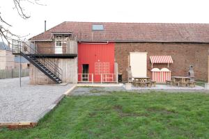 a barn with a red door and two benches at La Pause Picarde - Baie De Somme 2 in Franleu