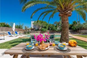 a wooden table with food and a palm tree at Las Estrellas Cala Llombards in Cala Llombards