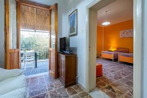 a room with a bed and a television and a balcony at Appartamento Maria- Castelsardo in Castelsardo