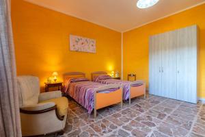 two beds in a room with yellow walls at Appartamento Maria- Castelsardo in Castelsardo