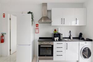 a kitchen with white cabinets and a washer and dryer at Mi Casa Es Su Casa Nº5 in Albufeira +5 photos