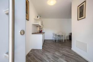 a room with a kitchen and a table with chairs at Appartamenti Gaggiolo 1 in Dro +12 photos