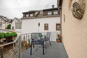 a patio with two chairs and a table on a balcony at Ferienwohnung Eulennest 2 in Minheim