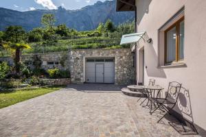a driveway with a garage and a table and chairs at Appartamenti Gaggiolo 1 in Dro
