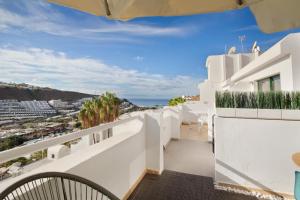 a balcony with white walls and a view of the ocean at Zen House in Puerto Rico de Gran Canaria