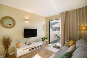 a living room with a couch and a tv at Zen House in Puerto Rico de Gran Canaria