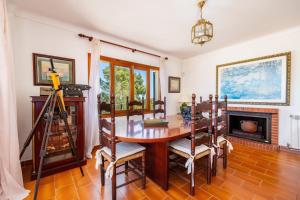 a dining room with a table and a fireplace at Es Puig de Ses Coves in Santa Eugenia