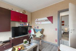 a living room with red cabinets and a television at Casa Heli 1 lake view in San Zeno di Montagna