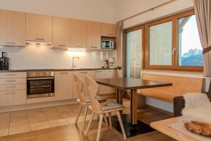 a kitchen with a wooden table and chairs in a room at Parndlehof in Villandro