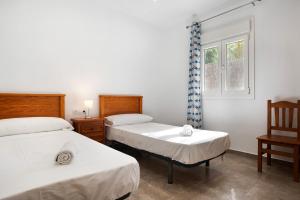 a bedroom with two beds and a window at Villa Montenmedio - Carmelo in El Soto +15 photos