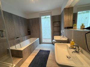 a bathroom with two sinks and a tub and a bath tub at Ferienwohnung Steni in Wehr +29 photos