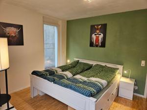 a bed in a room with a green wall at Ferienwohnung Steni in Wehr