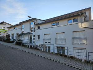a white apartment building with balconies on a street at Ferienwohnung Steni in Wehr