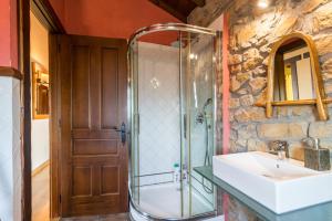 a bathroom with a glass shower and a sink at El Paraiso del Yayo in Ramales de la Victoria +22 photos
