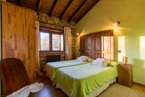a bedroom with two beds and a window at El Paraiso del Yayo in Ramales de la Victoria