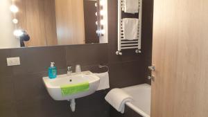 a bathroom with a sink and a toilet and a mirror at Modern apartament in Porlezza +14 photos
