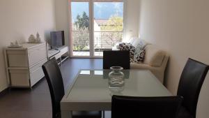 a living room with a table and chairs and a couch at Modern apartament in Porlezza