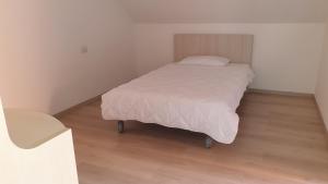 a bed in a small room with a wooden floor at Modern apartament in Porlezza