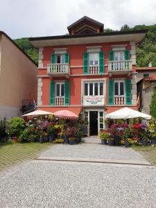 a building with flowers and umbrellas in front of it at Modern apartament in Porlezza