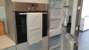 an open refrigerator with a towel on the door at Modern apartament in Porlezza