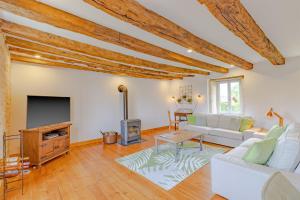 a living room with a white couch and a tv at Gite La Mauratie -4 chambres in Jayac