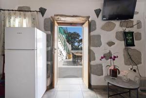 a kitchen with a refrigerator and a television on a wall at Vivienda Vacacional Risco Blanco in San Bartolomé