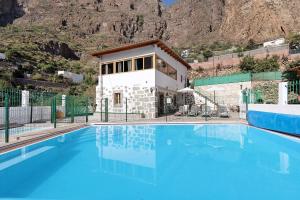 a large swimming pool in front of a house at Vivienda Vacacional Risco Blanco in San Bartolomé