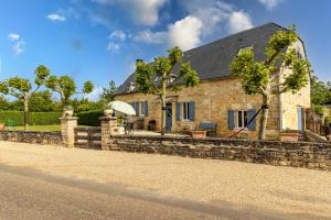 a stone house with a stone retaining wall at Gite La Mauratie -4 chambres in Jayac