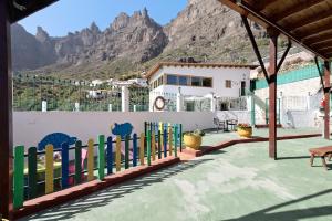 a house with a fence with mountains in the background at Vivienda Vacacional Risco Blanco in San Bartolomé