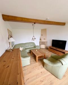 a living room with a couch and a table at Ferienappartement - Haus am See in Woltersdorf