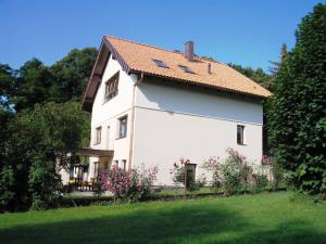 a white house with a red roof at Ferienappartement - Haus am See in Woltersdorf