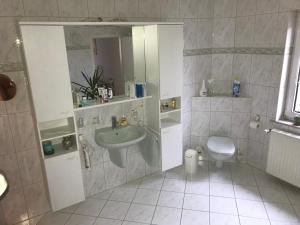 a bathroom with a sink and a toilet at Ferienappartement - Haus am See in Woltersdorf +24 photos