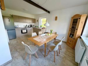 a kitchen and dining room with a wooden table and chairs at Ferienappartement - Haus am See in Woltersdorf
