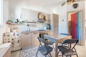 a kitchen with a wooden table and chairs at Gemma Piccolino in Villasimius