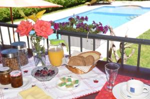 a table with bread and juice and flowers and a pool at Solar de Rabal in Bragança