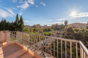 a balcony with a railing and trees and the sun at Caril in Binissalem