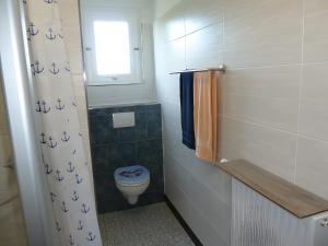 a bathroom with a toilet and a window at Angelas Ferienwohnung in Cuxhaven