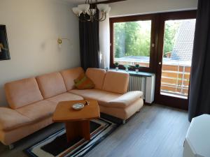 a living room with a couch and a table at Angelas Ferienwohnung in Cuxhaven +2 photos