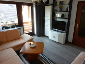 a living room with a couch and a tv and a table at Angelas Ferienwohnung in Cuxhaven