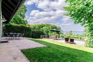 a patio with chairs and tables and an umbrella at Haus Seeblick in Langballig