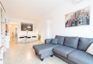 a living room with a blue couch and a table at Moli Apartment Beach in Canet de Mar