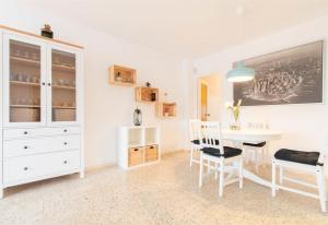 a white dining room with a white table and chairs at Moli Apartment Beach in Canet de Mar
