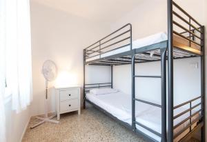 a bedroom with two bunk beds and a fan at Moli Apartment Beach in Canet de Mar