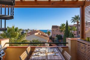 a table on a balcony with a view of the ocean at Topacio A114 in Mijas Costa