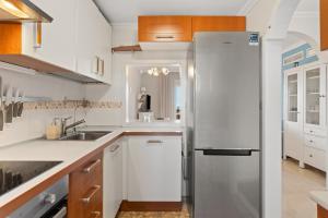 a kitchen with white cabinets and a refrigerator at Topacio A114 in Mijas Costa