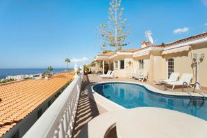 a villa with a swimming pool and a balcony at House Carla Private Pool Heated in Puerto de Santiago