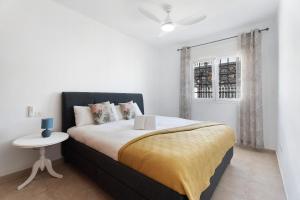 a bedroom with a bed with a table and a window at House Carla Private Pool Heated in Puerto de Santiago +26 photos