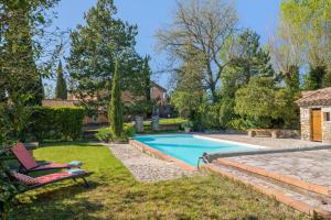 a swimming pool in a yard with a chair at Le Barry in Tulette