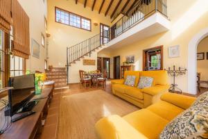 a living room with yellow couches and a tv at Estrella in Son Serra de Marina
